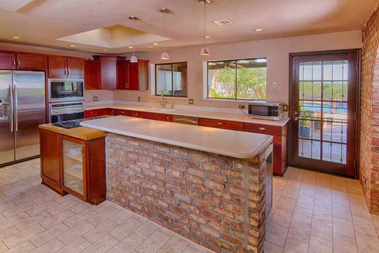 Pro-Remodeling Brick Island with red cabinets.